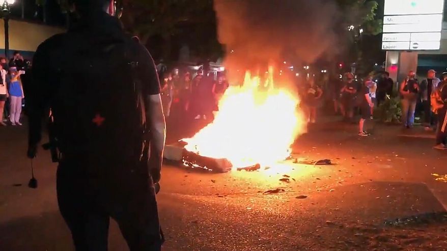 In this image taken from video a mattress burns in the street near the Portland Police Bureau&#39;s North Precinct Sunday night, Sept. 6, 2020, in Portland, Ore. Protesters have gathered for more than 100 days following the death of George Floyd in Minneapolis. (KATU Photo via AP)