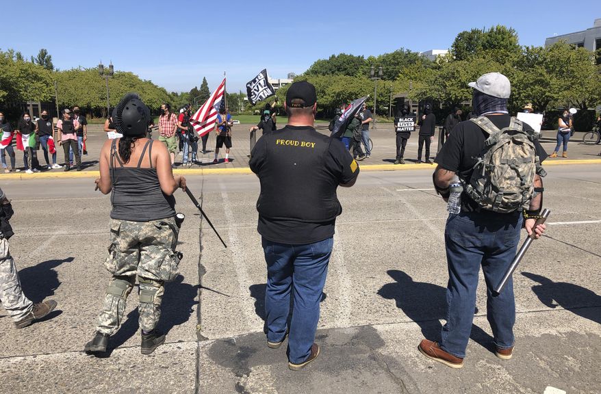 Supporters of President Donald Trump and Black Lives Matter protesters confront each other at the Oregon state Capitol in Salem, Ore. on Monday, Sept. 7, 2020. (AP Photo/Andrew Selsky)