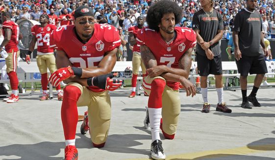 FILE - In this Sept. 18, 2016, file photo, San Francisco 49ers&#39; Colin Kaepernick (7) and Eric Reid (35) kneel during the national anthem before an NFL football game against the Carolina Panthers in Charlotte, N.C. Four years after Kaepernick spoke out against racism and eventually lost his job for peacefully protesting, the NFL supports his fight and now encourages players to stand up for racial equality and social justice.(AP Photo/Mike McCarn, File)