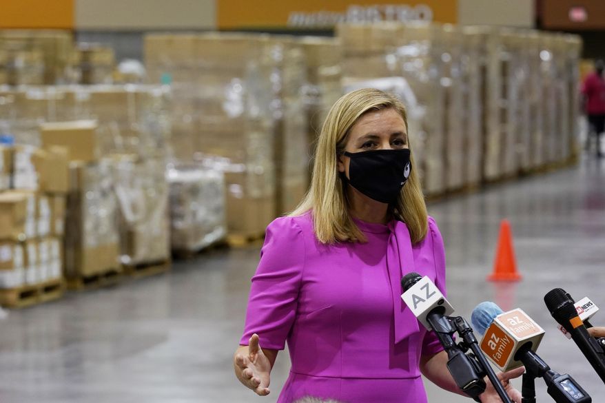 Phoenix Mayor Kate Gallego announces the arrival of more than one million pieces of PPE to help Phoenix schools reopen for the 2020-2021 school year as pallets fill a Phoenix Convention Center hall, Tuesday, Sept. 8, 2020, in Phoenix, as the city begins to ship the pallets out to schools. (AP Photo/Ross D. Franklin)