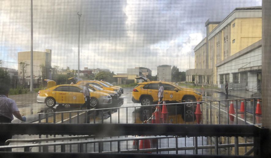 Taxis arrive to pick up passengers cleared to leave the centralized quarantine facility in Hukou township in Hsinchu county in Northern Taiwan on Monday, Aug. 31, 2020. (AP Photo/Wu Huizhong)