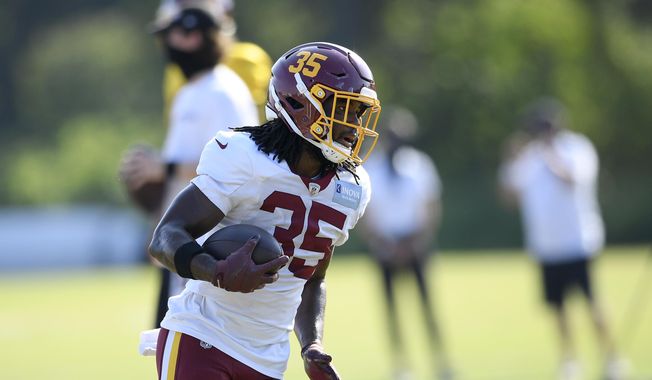 Washington running back Bryce Love (35) runs with the ball during practice at the team&#x27;s NFL football training facility, Monday, Aug. 24, 2020, in Ashburn, Va. (AP Photo/Nick Wass)  **FILE**