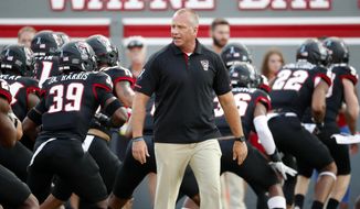 FILE - North Carolina State head coach Dave Doeren watches his team warm up prior to the start of an NCAA college football game against Ball State in Raleigh, N.C., Saturday, Sept. 21, 2019. Doeren said the team had three positive coronavirus tests over 2½ months before students returned. Clusters followed and the school soon paused all athletics activities, including football practices for about a week before postponing this weekend&#39;s game at Virginia Tech to Sept. 26.  (AP Photo/Karl B DeBlaker, File)