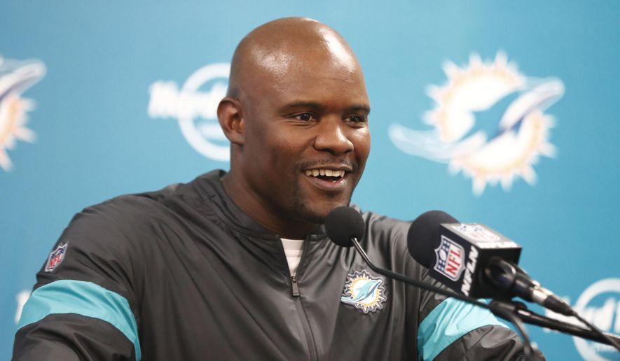 FILE - In this Dec. 22, 2019, file photo, Miami Dolphins head coach Brian Flores smiles during a news conference following an NFL football game against the Cincinnati Bengals in Miami Gardens, Fla. At least four Miami Dolphins rookies are expected to see significant action in Sunday’s, Sept. 12, 2020, opener. Flores allowed himself a slight smile when asked Wednesday, Sept. 9, 2020, how comfortable he was starting rookies in the season's first game.(AP Photo/Brynn Anderson, File)