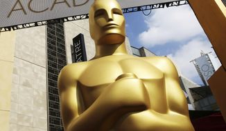 FILE - In this Feb. 21, 2015 file photo, an Oscar statue appears outside the Dolby Theatre for the 87th Academy Awards in Los Angeles. The Academy of Motion Picture Arts and Sciences laid out sweeping eligibility reforms to the best picture category intended to encourage diversity and equitable representation on and off screen beginning with the 96th Academy Awards. The announcement on Sept. 8, 2020, became a hotly debated topic on social media with some claiming it goes too far and others saying it doesn&#39;t go far enough. (Photo by Matt Sayles/Invision/AP, File)