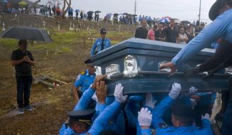 FILE - In this Sept. 29, 2017 file photo, police lift the coffin that contain the remains of a fellow officer who died while trying to cross a river in his car during the passage of Hurricane Maria, in Aguada, Puerto Rico. U.S. researchers who estimated that nearly 3,000 people died in Puerto Rico in the aftermath of Maria are now investigating deaths that might have been missed and could be linked to infrastructure damaged by the Category 4 storm, officials announced Wednesday, sept. 9, 2020.  (AP Photo/Ramon Espinosa, File)