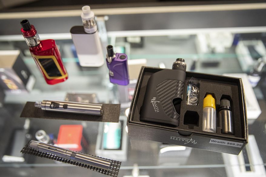 FILE - In this Thursday, Jan. 2, 2020 file photo, vaping devices are displayed at a store in New York. According to a Centers for Disease Control and Prevention report released on Wednesday, Sept. 9, 2020, vaping rates among U.S. teenagers fell dramatically in 2020. The drop comes in the wake of 2019’s outbreak of vaping-related illnesses and deaths. (AP Photo/Mary Altaffer)
