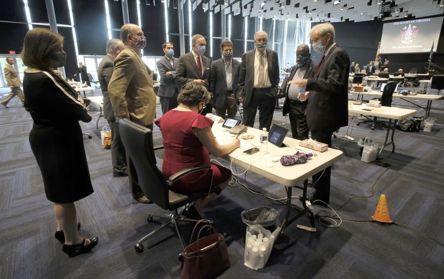 Senate Majority Leader Dick Saslaw, D-Fairfax, right, confers with Democratic colleagues during the Senate floor session in the temporary Virginia Senate chamber inside the Science Museum of Virginia in Richmond, Va., Thursday, Sept. 10, 2020. (Bob Brown/Richmond Times-Dispatch via AP)