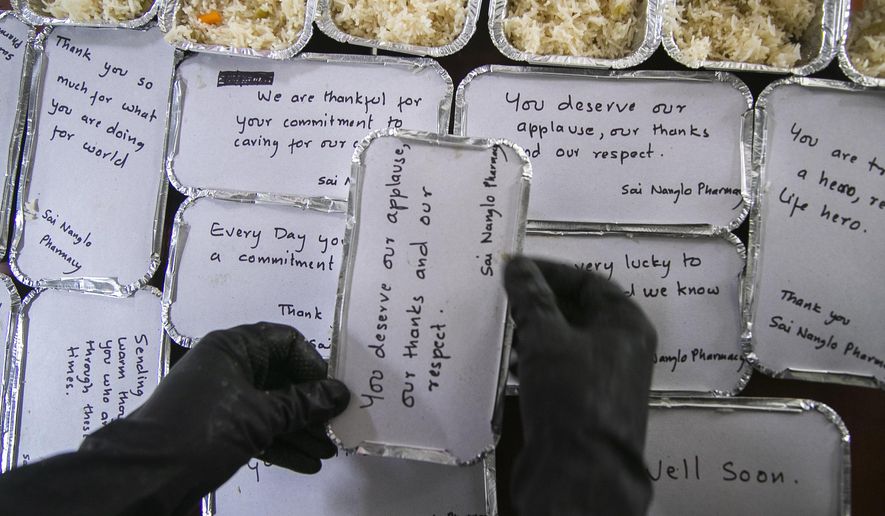 A Volunteer packs food for doctors and COVID-19 patients in Kathmandu, Nepal, Tuesday, Sept. 1, 2020. At one of the largest hospitals in Nepal, a pharmacist and taxi driver have teamed up to feed COVID-19 patients, doctors, nurses and health workers. Due to lockdowns, the cafeteria and nearby cafes have closed, leaving more than 200 staffers, patients and their families without food. The two friends have taken their own money and donations and put it to use buying groceries, renting a kitchen and paying helpers to provide the meals. (AP Photo/Niranjan Shrestha)