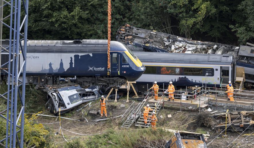 A carriage is lifted by crane from the site of the Stonehaven rail crash as work continues at the scene in Aberdeenshire, following the derailment of the ScotRail train on Aug. 12 which cost the lives of three people, in Stonehaven, Scotland, Thursday Sept. 10, 2020. An investigation into a train crash in Scotland last month that killed three people has found that the train “struck a pile of washed-out rock and gravel before derailing.” In the interim report, Network Rail said the industry needed to learn how to respond better in the future to severe weather. (Derek Ironside/Newsline Media/PA via AP)