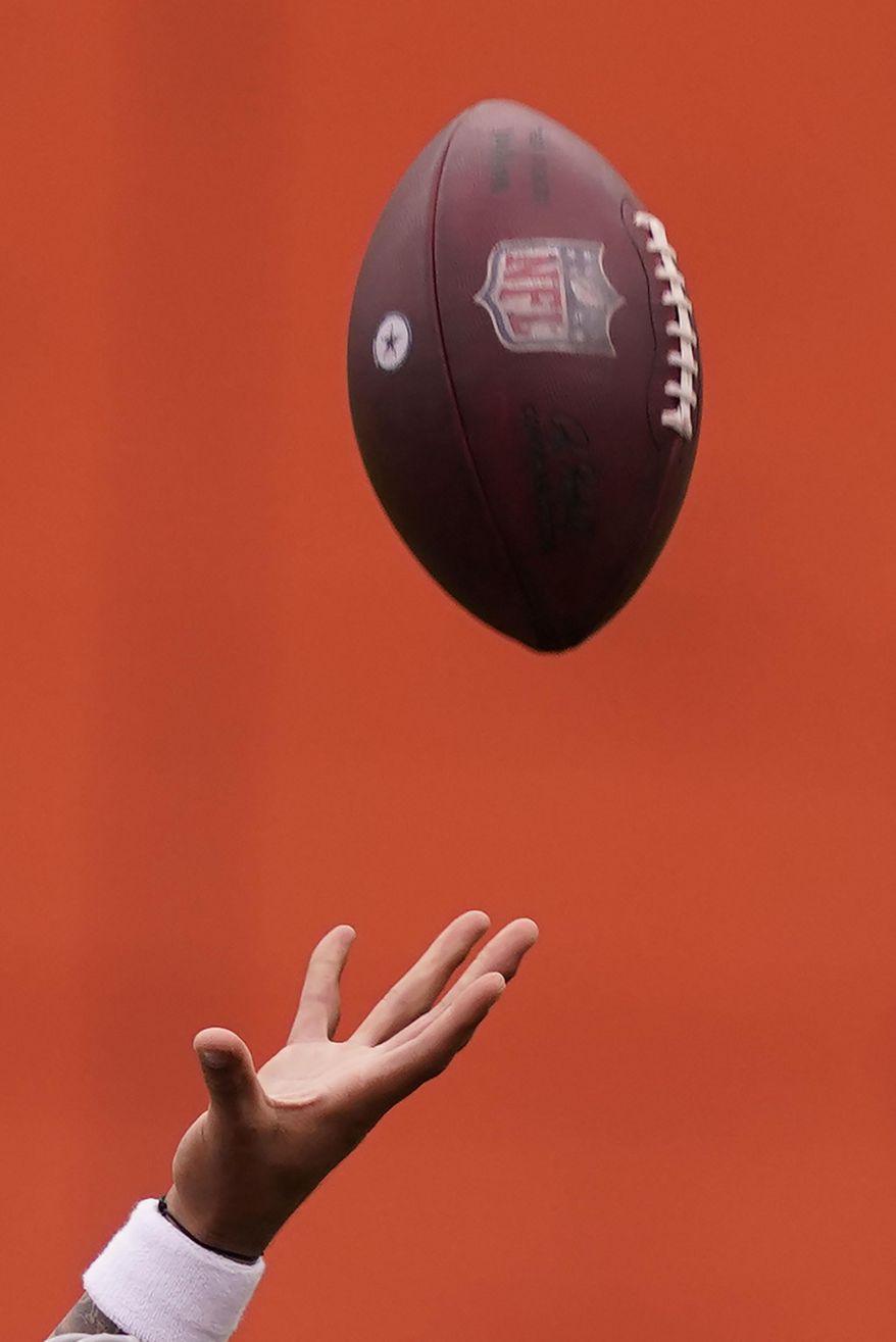 Dallas Cowboys quarterback Dak Prescott reaches to catch a football he tossed into the air while warming up for an NFL training camp football practice in Frisco, Texas, Thursday, Sept. 3, 2020. (AP Photo/LM Otero)