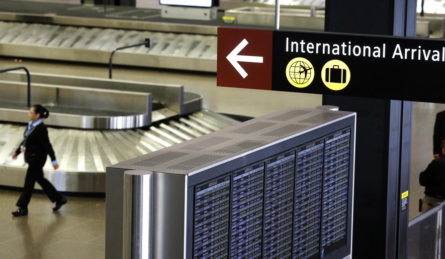 FILE - In this June 26, 2017, file photo, a sign for International Arrivals is displayed at the Seattle-Tacoma International Airport in Seattle. Beginning next week, the federal government plans to end the current system of temperature checks and travelers vouching for the health. Instead, the Centers for Disease Control and Prevention say they will focus on other measures including stronger reporting of illness at airports. The enhanced screening currently applies to people who have recently been in China, Iran, most European countries, the U.K., Ireland and Brazil. (AP Photo/Ted S. Warren, File)