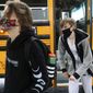 Sophomores Hunter Keith, left, and Carson Anderson get off the bus on the first day of in-person instruction at Jenks High School, Thursday, Sept. 10, 2020, amid the coronavirus pandemic, in Tulsa, Okla. (Mike Simons/Tulsa World via AP)