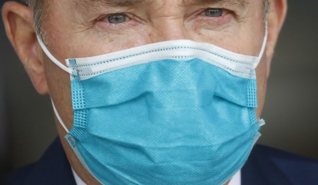 FILE - Utah Gov. Gary Herbert wears a mask during a news conference on April 15, 2020, in Salt Lake City. Utah has set new goals for fighting the coronavirus pandemic that include keeping the state's fatality rate below 1% and maintaining an unemployment rate below 4.5%, state leaders said. Gov. Gary Herbert and other state leaders rolled out their new plan, which prioritizes both public health and boosting the state's economy through the fall and winter. (AP Photo/Rick Bowmer, File)