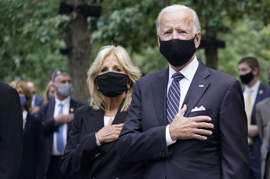 Democratic presidential candidate and former Vice President Joe Biden, right, and his wife Jill Biden stand for the pledge of allegiance during a ceremony marking the 19th anniversary of the 9/11 terrorist attacks at the National September 11 Memorial & Museum, Friday, Sept. 11, 2020, in New York. (AP Photo/Mary Altaffer)