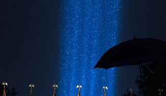 A beam of light are seen during a heavy rain over the Pentagon, as part of the Towers of Light Tribute marking the 19th anniversary of the 9/11 attack on the Pentagon, Wednesday, Sept. 9, 2020, in Washington. (AP Photo/Jose Luis Magana)