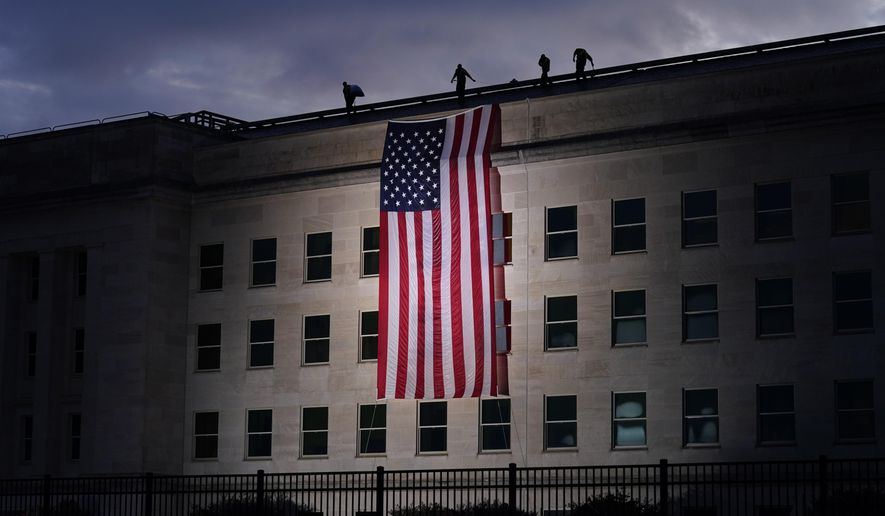 A large American flag is unfurled at the Pentagon ahead of ceremonies at the National 9/11 Pentagon Memorial to honor the 184 people killed in the 2001 terrorist attack on the Pentagon, in Washington, Friday Sept. 11, 2020. (AP Photo/J. Scott Applewhite) ** FILE **
