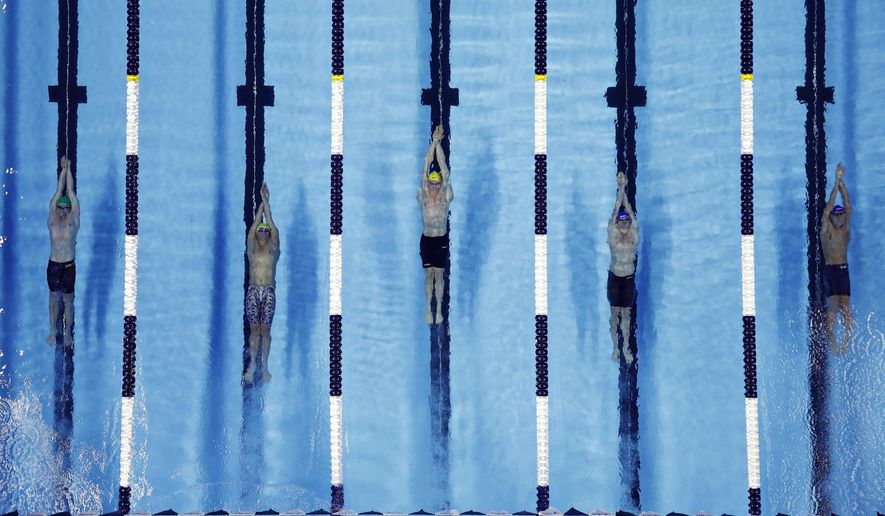 FILE - In this Dec. 20, 2019, file photo, swimmers compete in the men's 200-meter backstroke during an International Swimming League event in Las Vegas. The International Swimming League is making some changes ahead of its second season as a result of the coronavirus pandemic. The single-site training and competition schedule is a concession to COVID-19. Last year, the league held its meets in the U.S. and Europe. It's not yet clear what coronavirus protocols will be in place. (AP Photo/John Locher, File)