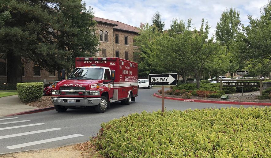 FILE - In this Aug. 30, 2018, file photo, an ambulance leaves Western State Hospital in Lakewood, Wash. As coronavirus cases spike at Washington state&#39;s largest psychiatric hospital, workers are pleading with officials to save them not just from the disease, but also from the violence that continues to plague the facility. (AP Photo/Martha Bellisle, File)