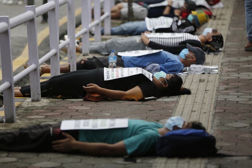 FILE - In this June 20, 2020, file photo, protesters lie on the ground demanding better handling of the COVID-19 pandemic in Kathmandu, Nepal. (AP Photo/Niranjan Shrestha, File)