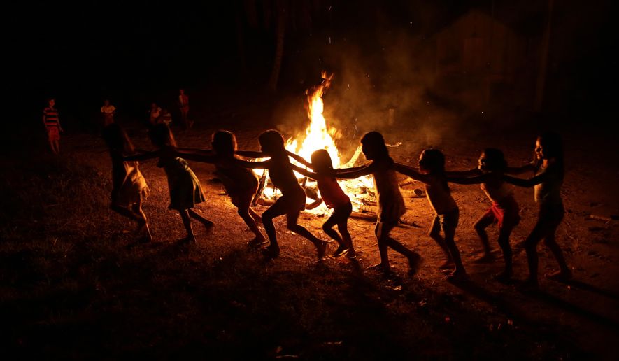 Tenetehara Indigenous children play around a campfire during a festival in the Alto Rio Guama Indigenous Reserve, where they have enforced six months of isolation during the new coronavirus pandemic, near the city of Paragominas, Brazil, Monday, Sept. 7, 2020. The Indigenous group, also known as Tembe, are celebrating and giving thanks that none of their members have fallen ill with COVID-19. (AP Photo/Eraldo Peres)