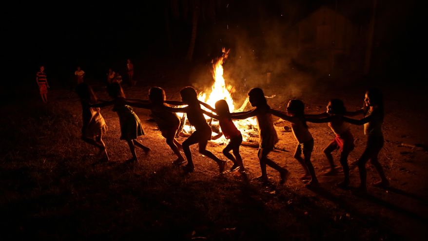 Tenetehara Indigenous children play around a campfire during a festival in the Alto Rio Guama Indigenous Reserve, where they have enforced six months of isolation during the new coronavirus pandemic, near the city of Paragominas, Brazil, Monday, Sept. 7, 2020. The Indigenous group, also known as Tembe, are celebrating and giving thanks that none of their members have fallen ill with COVID-19. (AP Photo/Eraldo Peres)
