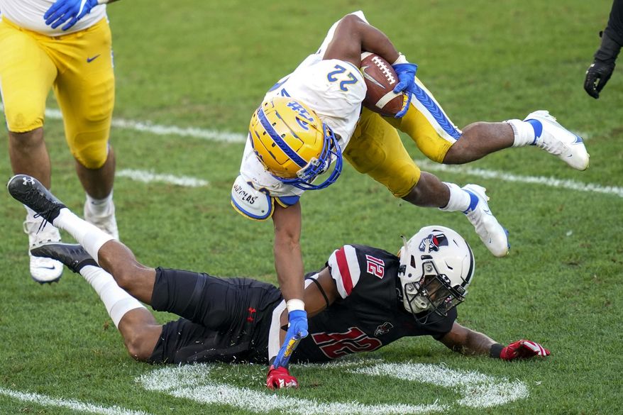 Pittsburgh running back Vincent Davis (22) tries to avoide Austin Peay cornerback Nathan Page (12) on a run during the second half of an NCAA college football game Saturday, Sept. 12, 2020, in Pittsburgh. (AP Photo/Keith Srakocic)