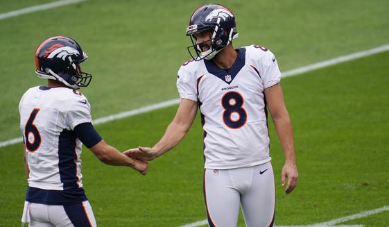 Denver Broncos punter Sam Martin, left, slaps hands with placekicker Brandon McManus as they take part in drills during an NFL football practice in empty Empower Field at Mile High, Saturday, Aug. 29, 2020, in Denver. (AP Photo/David Zalubowski)