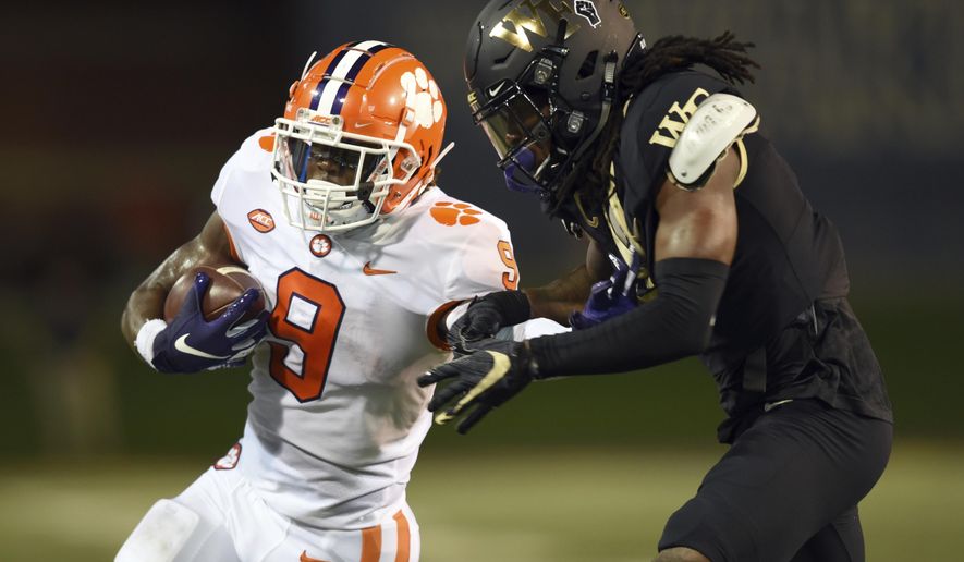 Clemson running back Travis Etienne, left, is taken down by Wake Forest's Ja'Sir Taylor after a long run in the first half of an NCAA college football game Saturday, Sept. 12, 2020, in Winston-Salem, N.C. (Walt Unks/The Winston-Salem Journal via AP)