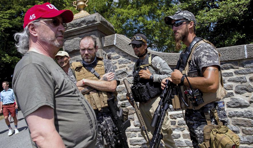 A group of individuals, some armed, talk near an entrance to the Gettysburg National Cemetery in Gettysburg National Military Park on Saturday, July 4, 2020 in Gettysburg, Pa. Since their birth in the mid-1990s, groups calling themselves constitutional militia have primarily stayed hidden, but this year, they&#39;re out — fully armed — to patrol demonstrations or rally at the state capital demanding reopening of businesses during the pandemic.  (Dan Rainville/York Daily Record via AP)