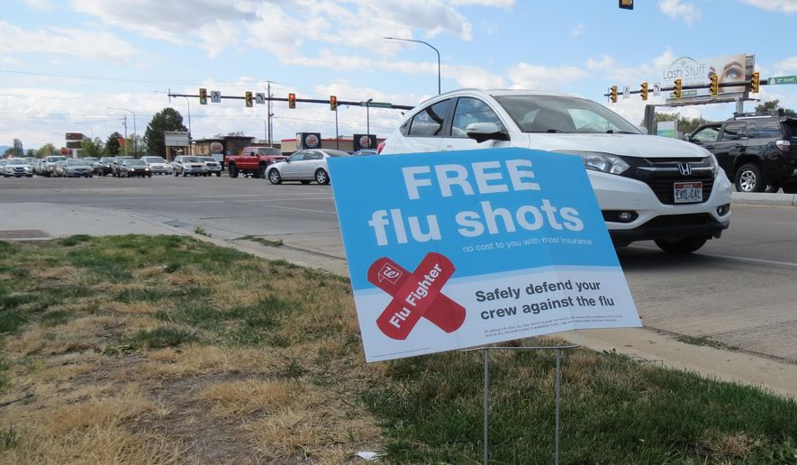 A sign advertising flu shots is displayed on Tuesday, Sept. 8, 2020, in in Ogden, Utah. The annual flu season is gearing up alongside the coronavirus pandemic, and Utah health officials are encouraging people to get their flu shots. (Tim Vandenack/Standard-Examiner via AP)