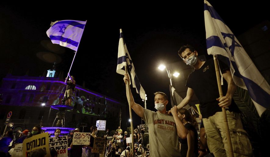 Israeli protesters wave flags during a demonstration against Israeli Prime Minister Benjamin Netanyahu outside the Prime Minister&#39;s residence in Jerusalem, Saturday, Sept. 12, 2020. (AP Photo/Sebastian Scheiner)