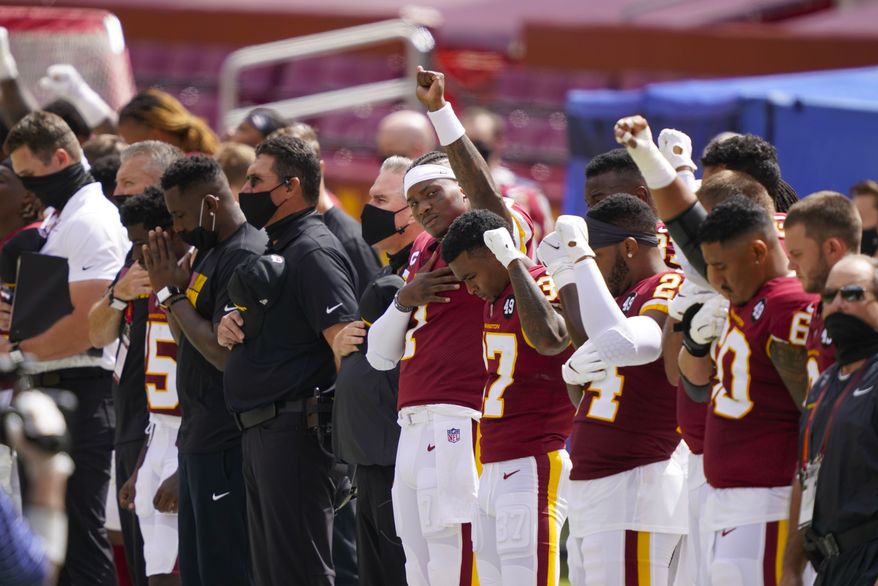 Washington Football Team quarterback Dwayne Haskins (7) and others hold their fist in the air during the national anthem before the start of an NFL football game against the Philadelphia Eagles, Sunday, Sept. 13, 2020, in Landover, Md. (AP Photo/Alex Brandon)  **FILE**