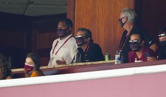 Washington Football Team owner Dan Snyder, center, watches from owner&#x27;s box the second half of an NFL football game against the Philadelphia Eagles, Sunday, Sept. 13, 2020, in Landover, Md. (AP Photo/Alex Brandon)
