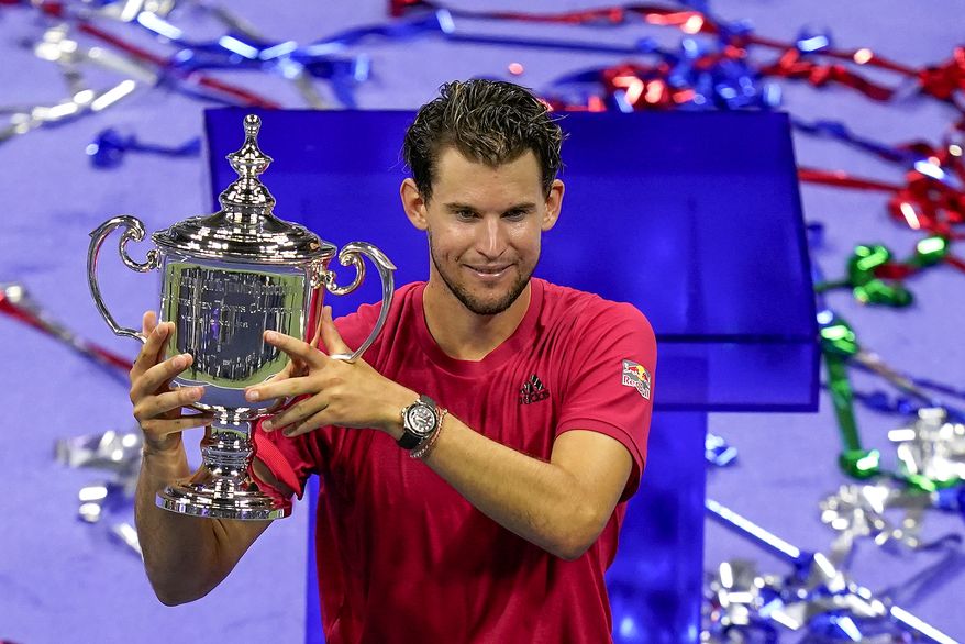 Dominic Thiem, of Austria, holds up the championship trophy after defeating Alexander Zverev, of Germany, in the men's singles final of the US Open tennis championships, Sunday, Sept. 13, 2020, in New York. (AP Photo/Seth Wenig)