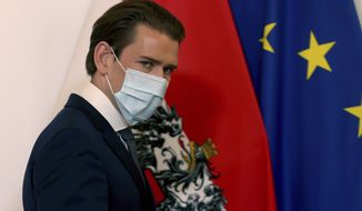 Austrian Chancellor Sebastian Kurz walks wearing a face mask, at the federal chancellery in Vienna, Austria, Sunday, Sept. 13, 2020. The Austrian government has moved to restrict freedom of movement for people, in an effort to slow the onset of the COVID-19 coronavirus. (AP Photo/Ronald Zak)