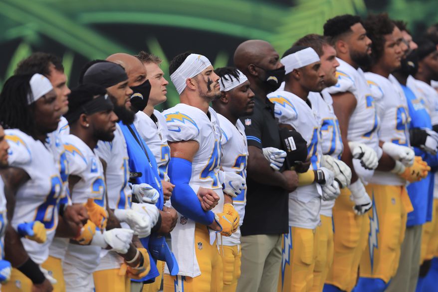 The Los Angeles Chargers stand arm-in-arm as &quot;Lift Every Voice and Sing&quot; is played before an NFL football game against the Cincinnati Bengals, Sunday, Sept. 13, 2020, in Cincinnati. (AP Photo/Aaron Doster)