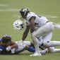 Indianapolis Colts wide receiver Michael Pittman loses his helmet after he was tackled by Jacksonville Jaguars middle linebacker Myles Jack and cornerback C.J. Henderson, back, during the second half of an NFL football game, Sunday, Sept. 13, 2020, in Jacksonville, Fla. (AP Photo/Phelan M. Ebenhack)