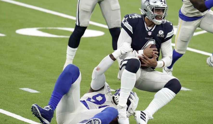 Dallas Cowboys quarterback Dak Prescott, right, is tackled by Los Angeles Rams defensive end Michael Brockers during the first half of an NFL football game Sunday, Sept. 13, 2020, in Inglewood, Calif. (AP Photo/Jae C. Hong )