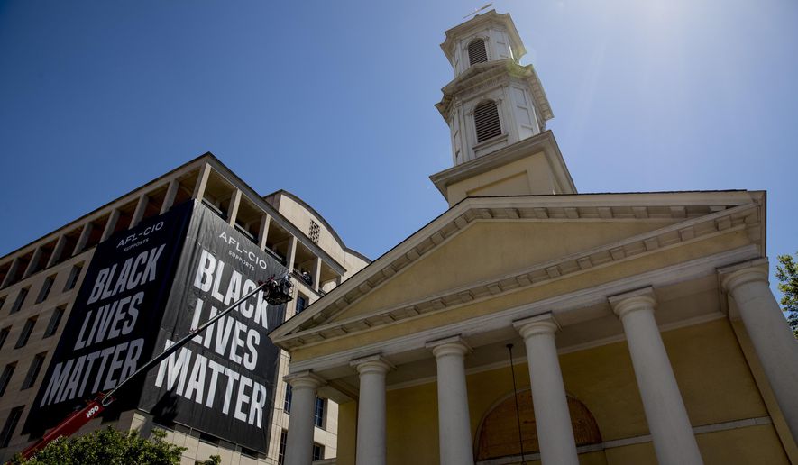 FILE - This Friday, June 12, 2020 file photo shows St. John&#39;s Episcopal Church next to a large &amp;quot;Black Lives Matter&amp;quot; banner on the AFL-CIO building near the White House in Washington. In 2020, mainline Protestant denominations, including the Episcopal, United Methodist and Presbyterian-USA churches, are now deeply engaged in campaigns against racism and voter suppression. (AP Photo/Andrew Harnik)