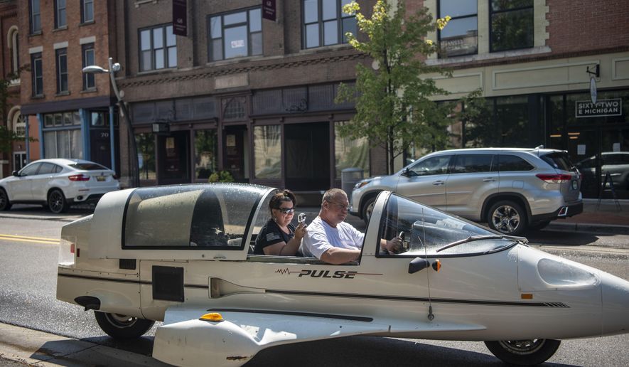 Andy and Ginger Segar cruise down Michigan Avenue in their Pulse autocycle on Friday, Aug. 28, 2020, in Battle Creek, Mich. Andy purchased the Owosso Pulse, made by the Owosso Motor Company, from his friend&#x27;s father, a childhood dream come true.  (Alyssa Keown/Battle Creek Enquirer via AP)