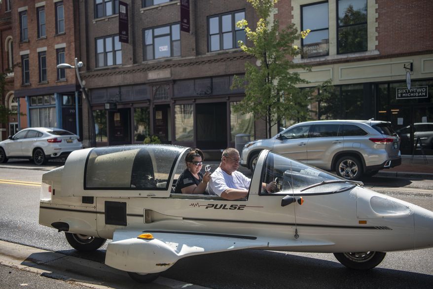 Andy and Ginger Segar cruise down Michigan Avenue in their Pulse autocycle on Friday, Aug. 28, 2020, in Battle Creek, Mich. Andy purchased the Owosso Pulse, made by the Owosso Motor Company, from his friend's father, a childhood dream come true. (Alyssa Keown/Battle Creek Enquirer via AP)