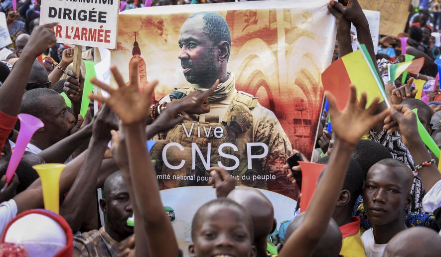 People hold a banner showing Col. Assimi Goita, leader of the junta which is now running Mali and calls itself the National Committee for the Salvation of the People, as they demonstrate to show support for the junta in the capital Bamako, Mali, Tuesday, Sept. 8, 2020. Placard at left in French reads &amp;quot;An army-led transition&amp;quot;. (AP Photo)