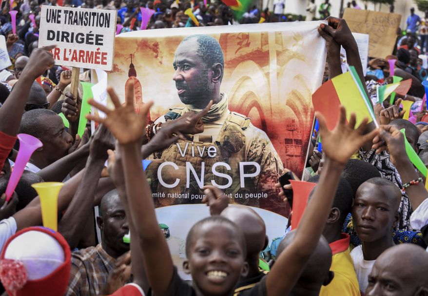 People hold a banner showing Col. Assimi Goita, leader of the junta which is now running Mali and calls itself the National Committee for the Salvation of the People, as they demonstrate to show support for the junta in the capital Bamako, Mali, Tuesday, Sept. 8, 2020. Placard at left in French reads &amp;quot;An army-led transition&amp;quot;. (AP Photo)