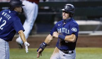 Seattle Mariners&#39; Dylan Moore, right, celebrates his run scored against the Arizona Diamondbacks with teammate Evan White, left, during the ninth inning of a baseball game Sunday, Sept. 13, 2020, in Phoenix. (AP Photo/Ross D. Franklin)