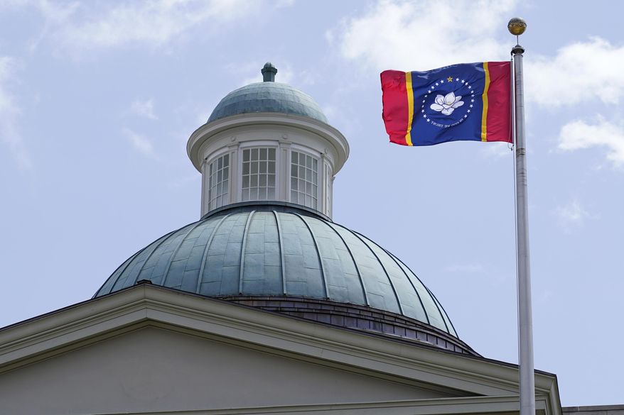 The magnolia flower centered banner chosen Wednesday, Sept. 2, 2020 by the Mississippi State Flag Commission flies outside the Old State Capitol Museum in downtown Jackson, Miss. The nine member committee voted to recommend a design with the state flower, now known as the &amp;quot;In God We Trust,&amp;quot; flag. That design will go on the November ballot for voters consideration and if approved, it will become the new state flag. (AP Photo/Rogelio V. Solis)