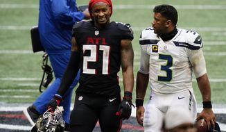 Atlanta Falcons running back Todd Gurley, left, speaks with Seattle Seahawks quarterback Russell Wilson after the second half of an NFL football game, Sunday, Sept. 13, 2020, in Atlanta. The Seattle Seahawks won 38-25. (AP Photo/Brynn Anderson)