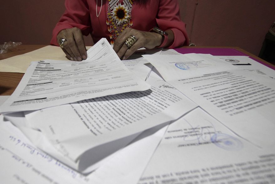 A Salvadoran businesswoman, who is one of the applicants of a small refugee program that was shut down by President Donald Trump, shows documents of the many times she has reported robberies and extortions, in Santa Ana, El Salvador, Saturday, Aug. 22, 2020. She said she was terrified when she began receiving death threats in 2013. Men with tattoos would come to a car wash she used to own to demand &amp;quot;monthly compensation&amp;quot; for letting her operate. She says she has received many threats since — through calls, text messages and social media. (AP Photo/Salvador Melendez)