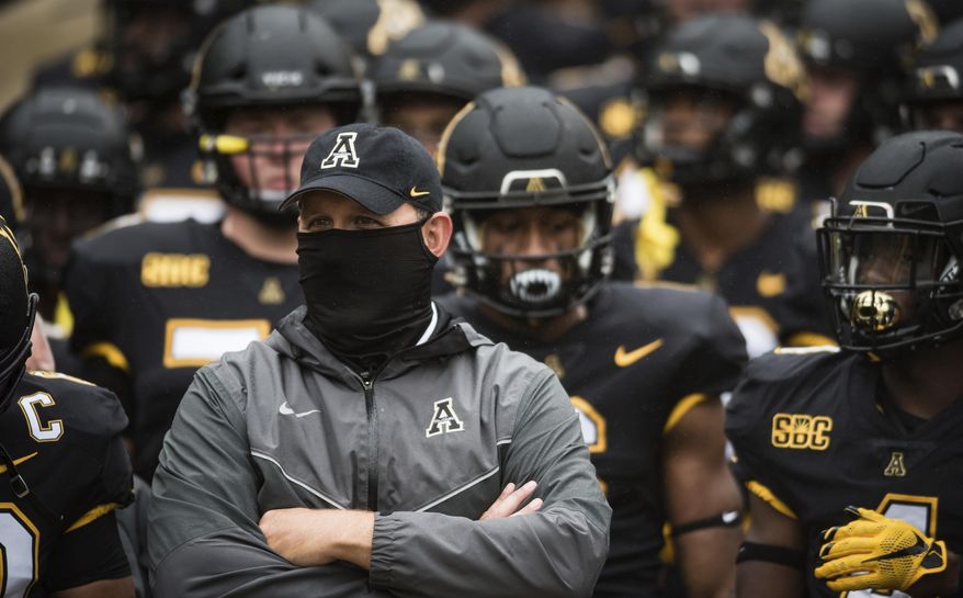 Appalachian State coach Shawn Clark stands with his team prior to an NCAA college football game against Charlotte on Saturday, Sept. 12, 2020, in Boone, N.C. (Allison Lee Isley/The Winston-Salem Journal via AP)