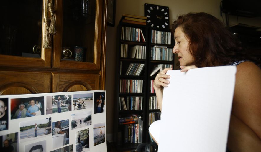 Christina Ihlenfeldt of Clinton Township, Mich., looks at old photos of her late husband in her home on Tuesday, Aug. 25, 2020. She became widowed, unemployed and lost $30,000 from a scam in one week. Heartbroken and vulnerable, the scam group using the name Geek Squad conned her into wiring them money to fix her computer. Her late husband, Robert Ihlenfeldt passed away on Friday, Aug. 7, 2020. (Rodney Coleman-Robinson/Detroit Free Press via AP)